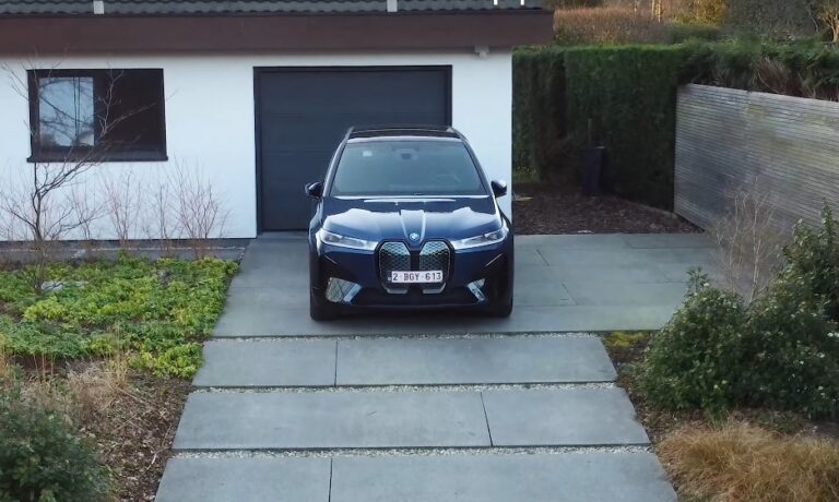Dark blue BMW IX parked on a paved driveway