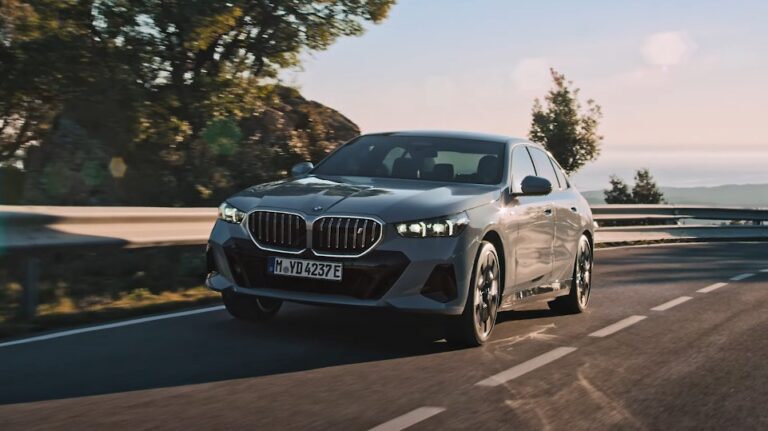 Sleek gray BMW sedan gliding along a scenic highway