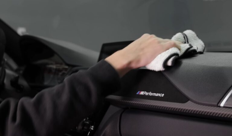 A microfiber cloth gently cleans a car's interior trim