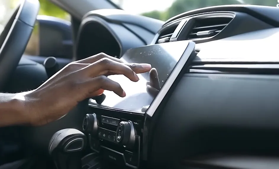 A hand navigates the in-car touchscreen, fingers dancing across the responsive display