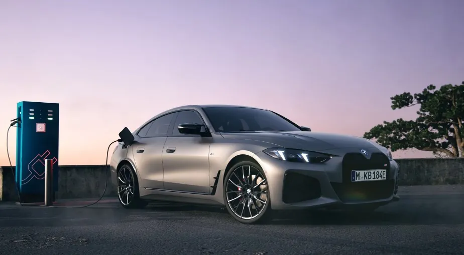 A sleek gray electric BMW is connected to a charging station