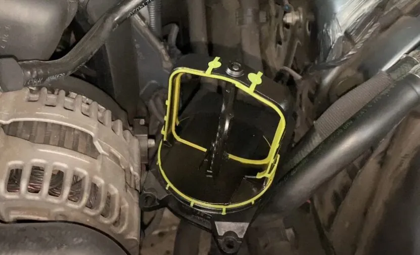 Close-up view of a black engine component with yellow markings