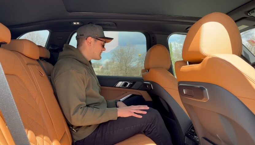 A man seated in the back seat of a car