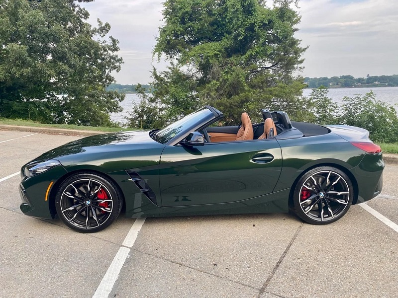 Dark green BMW Z4 M40i convertible with tan interior, parked lakeside and featuring a manual transmission