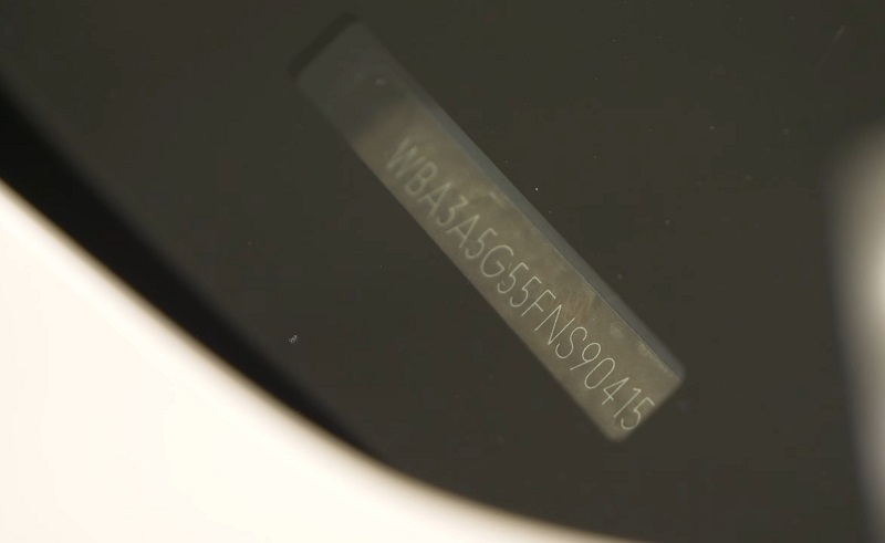 Close-up view of a BMW vehicle identification number (VIN) displayed on the dashboard through the windshield