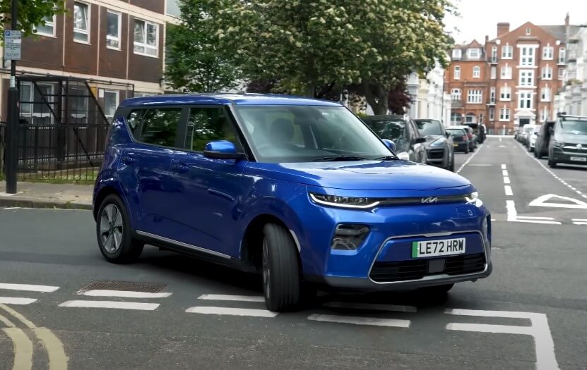 Blue Kia Soul driving through city streets