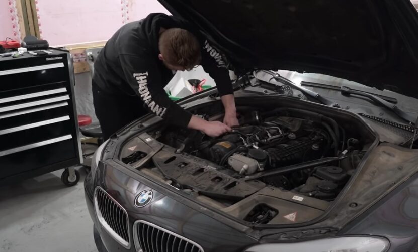 A mechanic works on a BMW engine