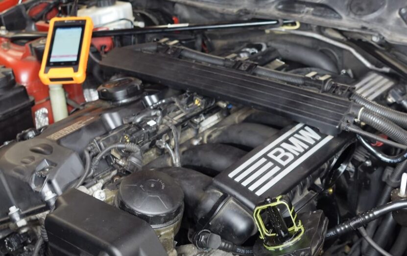 Close-up view of a BMW engine, with diagnostic tool connected