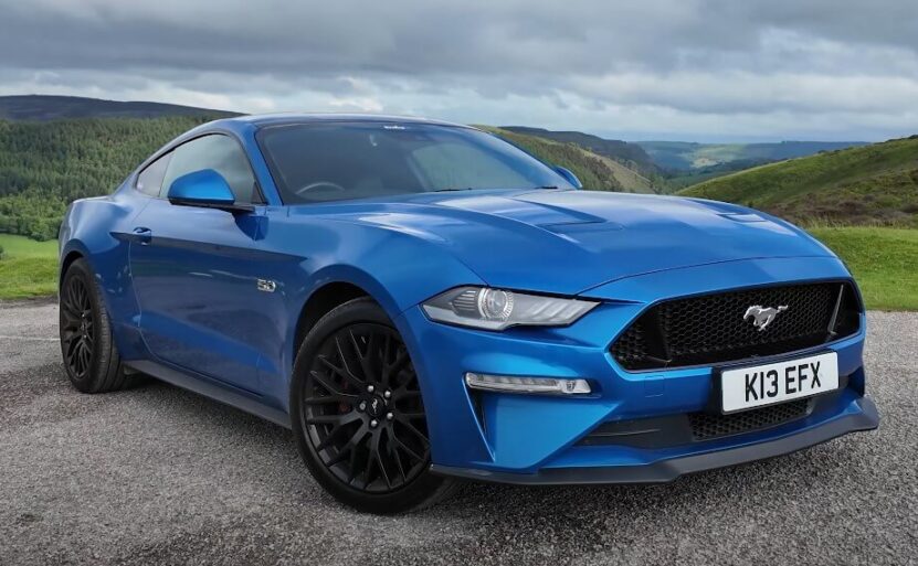 Blue Ford Mustang parked on a paved road