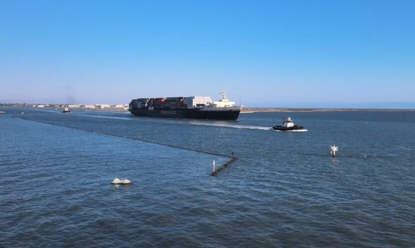 A large container ship navigates a channel