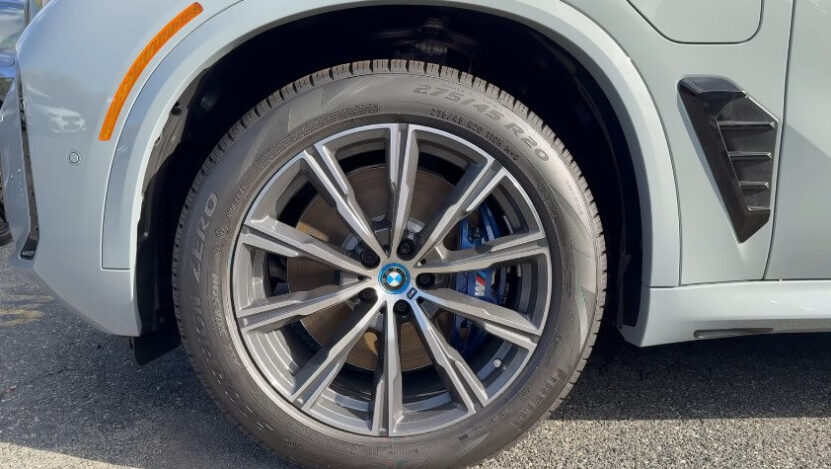 A close-up view of a modern, light gray SUV's wheel and tire