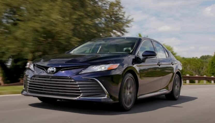 Sleek, dark-colored sedan gliding down the road