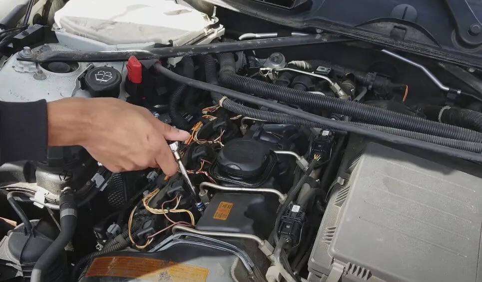 Close-up view of a mechanic's hands working on a car engine