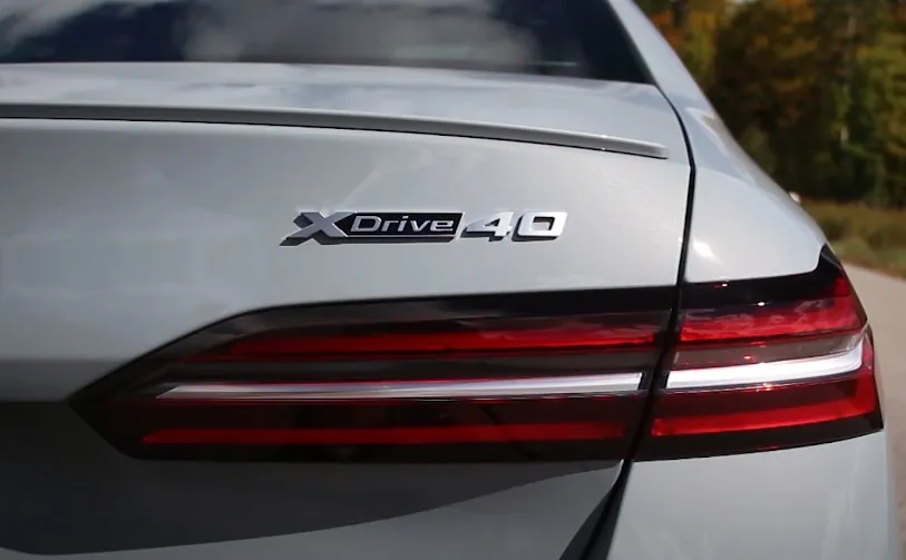 The XDrive 40 badge is prominently displayed on the light gray vehicle's rear