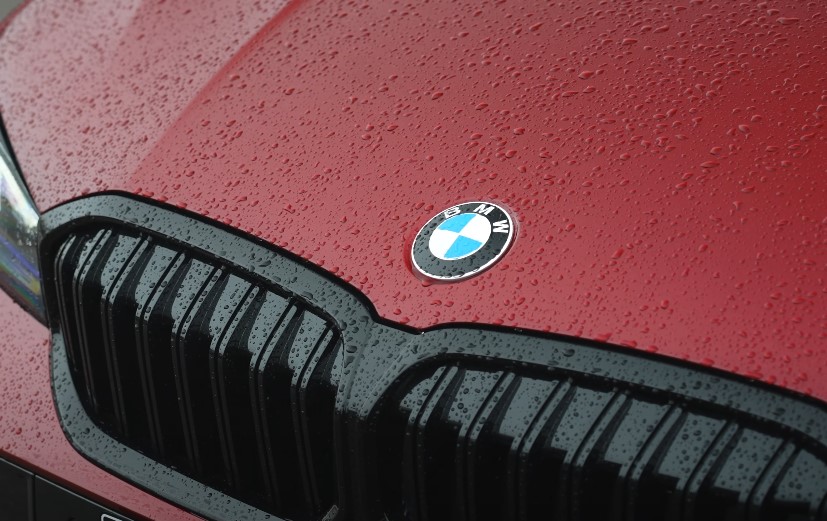BMW hood, wet with raindrops, showcasing the iconic logo