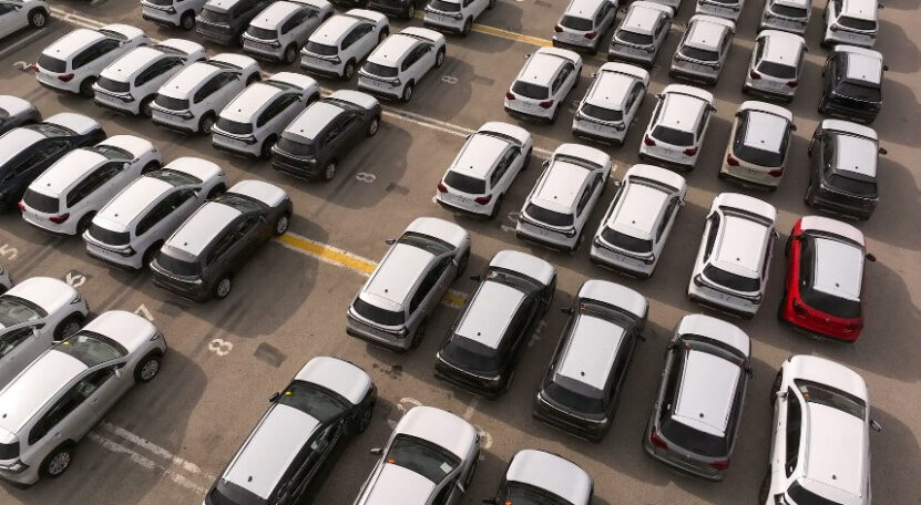 A vast array of vehicles, neatly organized in rows and columns, awaiting distribution