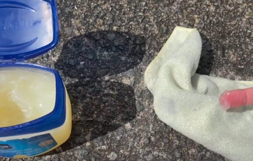 Petroleum jelly container open on a textured surface, ready for application