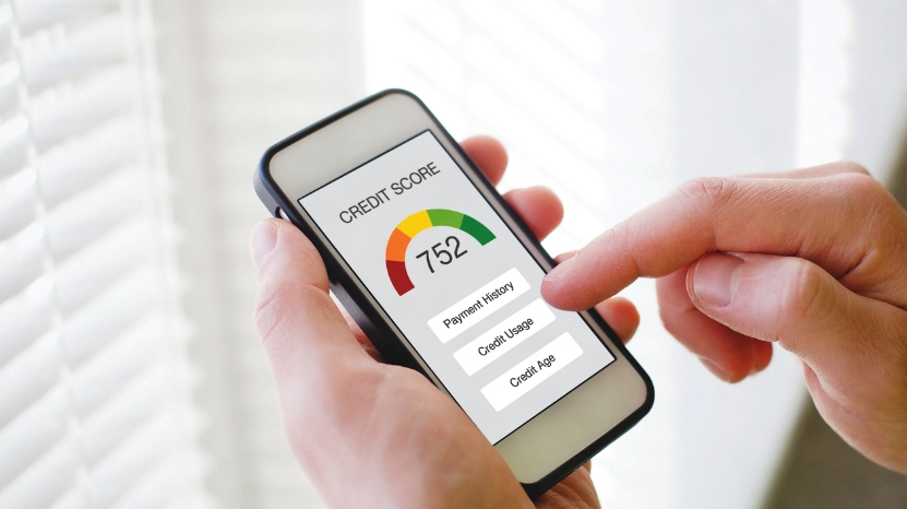 A person checks their credit score on a smartphone, showing how buyers track credit to get better auto loan deals