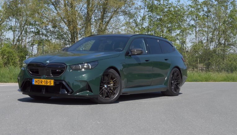 A high-performance BMW Touring, its deep green paint gleaming under the bright sunlight