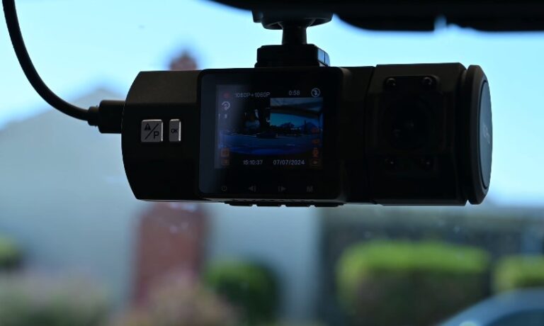 A dashcam mounted securely to the windshield, displaying a clear view of the road ahead