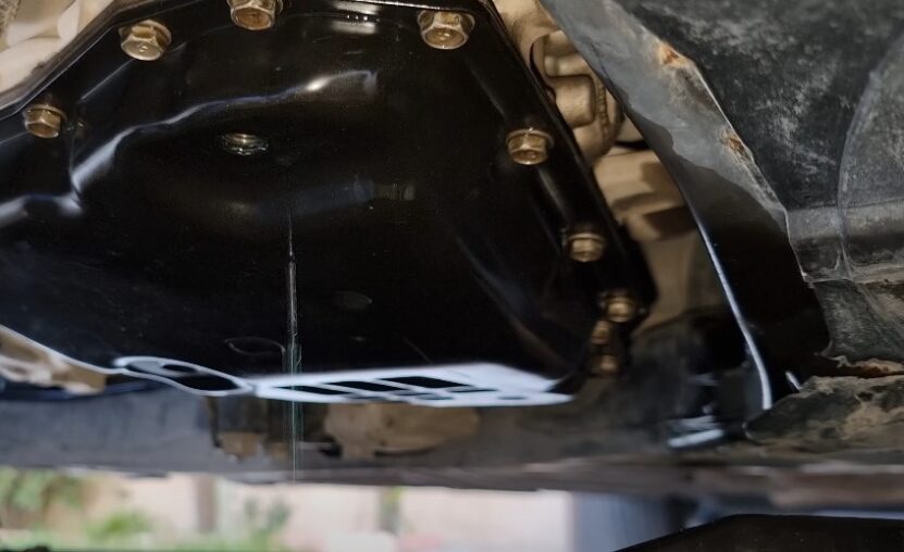 Close-up of an oil pan, showing the intricate details of the bolts and the surrounding metal