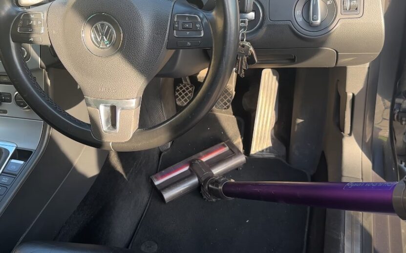 A purple vacuum cleaner tackles the car's interior, leaving behind a pristine space