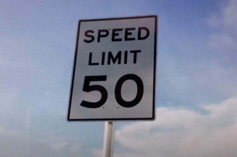 A 50 mph speed limit sign, clearly displayed against a light blue sky
