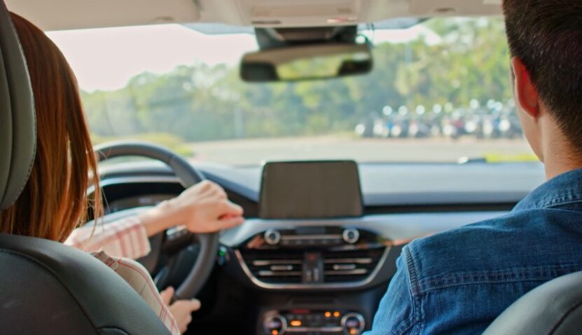 A couple sits comfortably inside a modern vehicle, ready for a journey