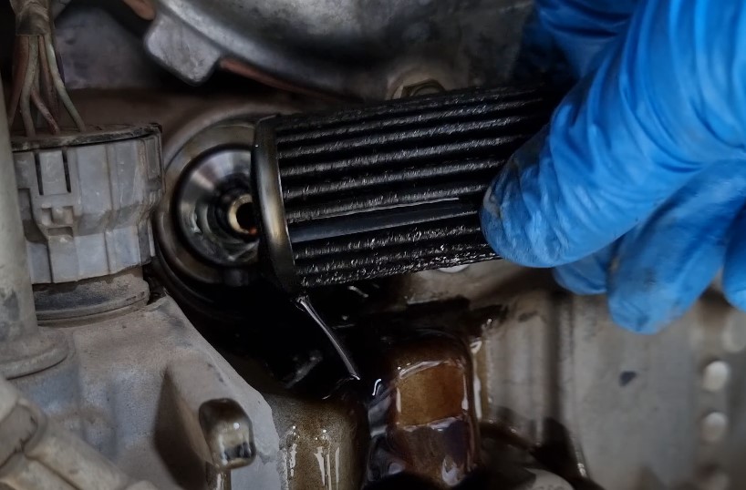 Close-up of a dirty transmission oil filter being removed