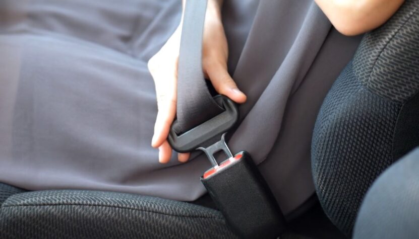 Close up view of a person securing a car seat belt