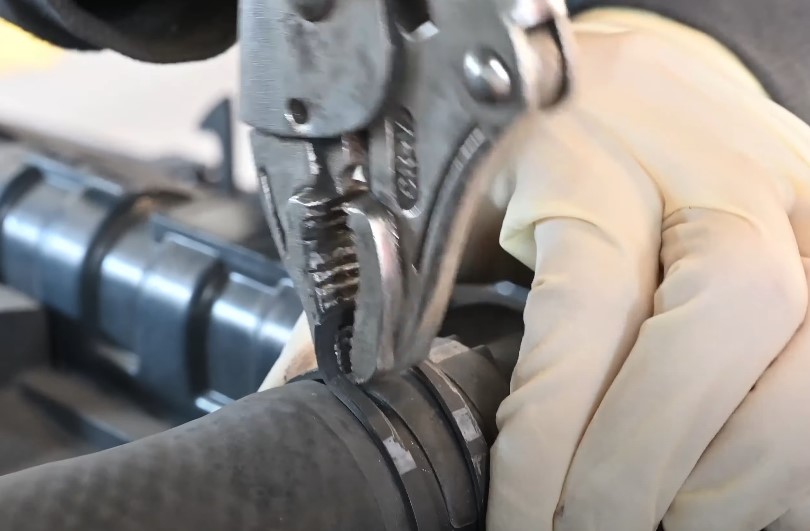 Mechanic carefully trying to attach engine hose