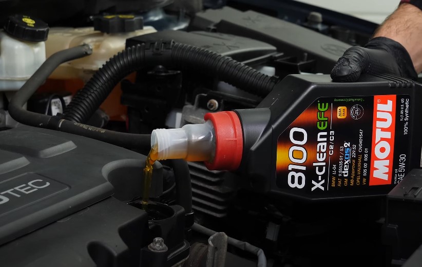 Engine oil being poured into the engine compartment
