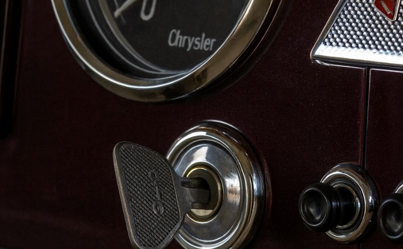 A vintage Chrysler ignition key, nestled in its precise metal casing