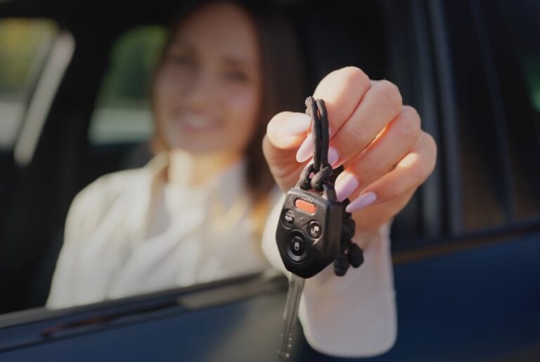 A woman holding a car key in her hand