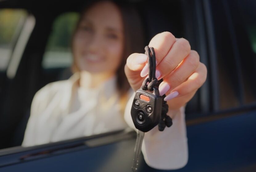 A woman holding a car key in her hand