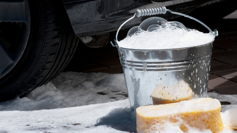 A soapy bucket and sponge next to a car show San Francisco’s ban on used underwear for washing cars
