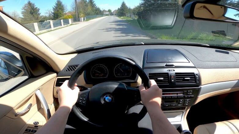 A man drives old BMW X3 SUV, first-person view
