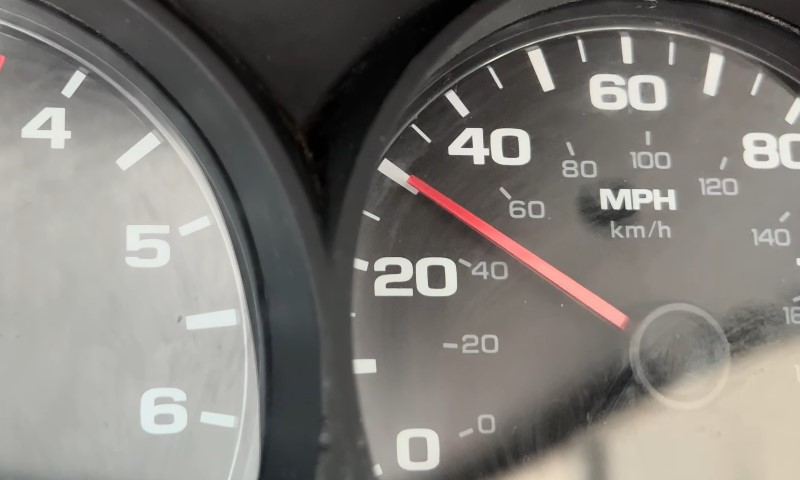 Close-up of a car speedometer, displaying the current speed in miles per hour against a black background