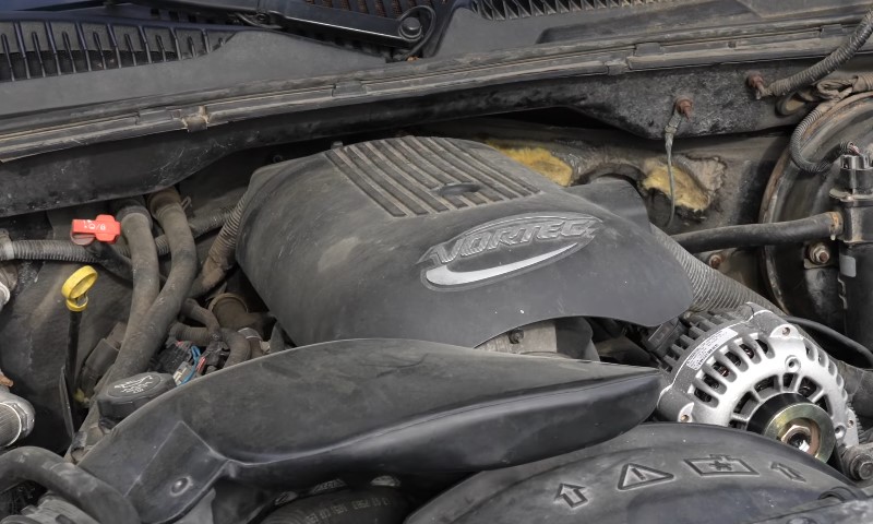 A car engine is visible with the hood open