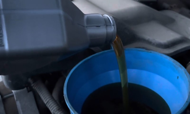 Oil is being poured into a car engine