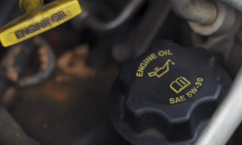 Close-up of an engine's yellow and black oil cap