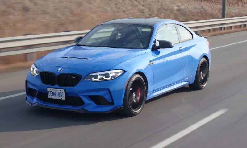 A sleek blue sports car speeds down a highway, exuding power and elegance