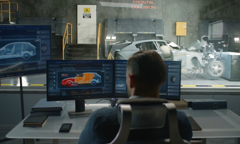 A person analyzes simulated car crash data on two monitors in a lab
